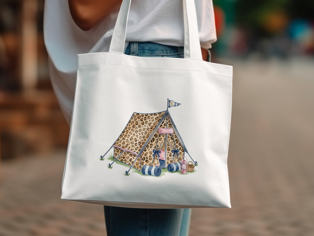 White tote bag with illustration of a leopard print tent with camping gear.