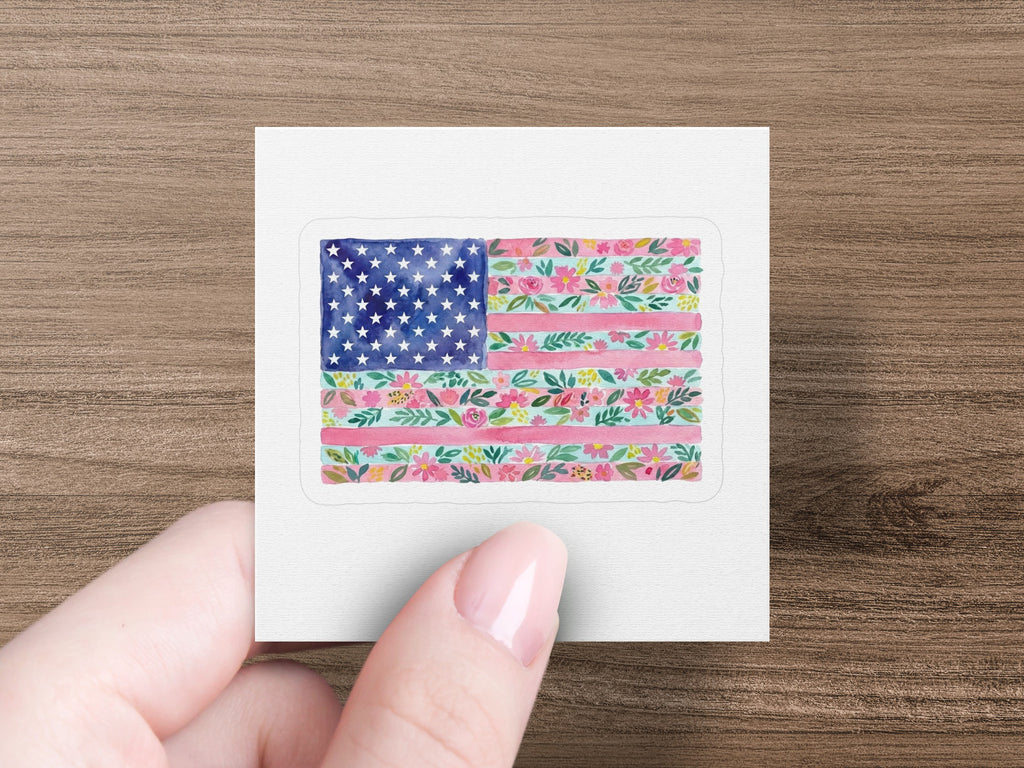 American flag design with floral pattern on sticker held by hand.