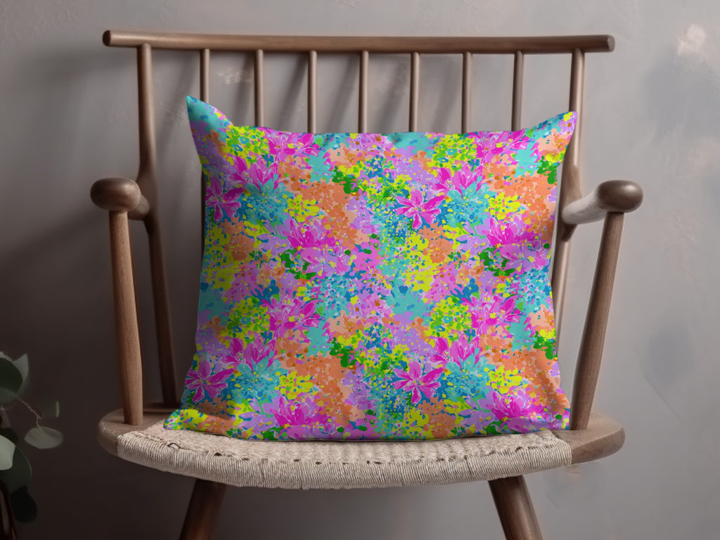 Throw pillow with a vibrant, abstract floral pattern in pink, blue, and orange.
