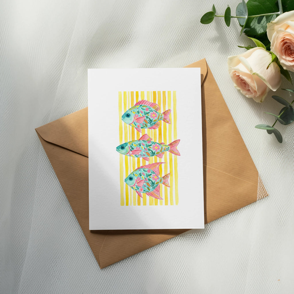 Card with three stylized pink and turquoise fish on a yellow striped background.