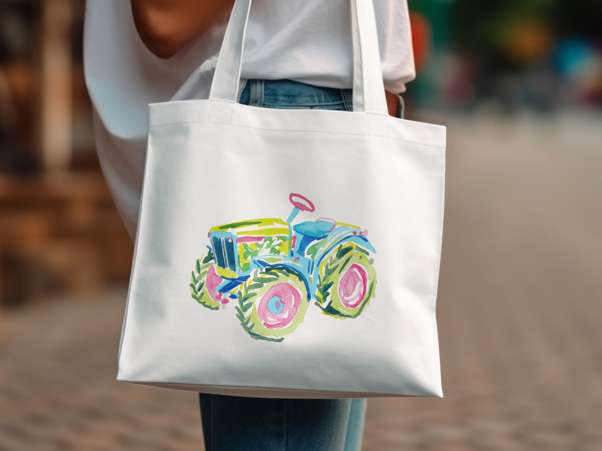 White tote bag with a colorful watercolor tractor illustration.