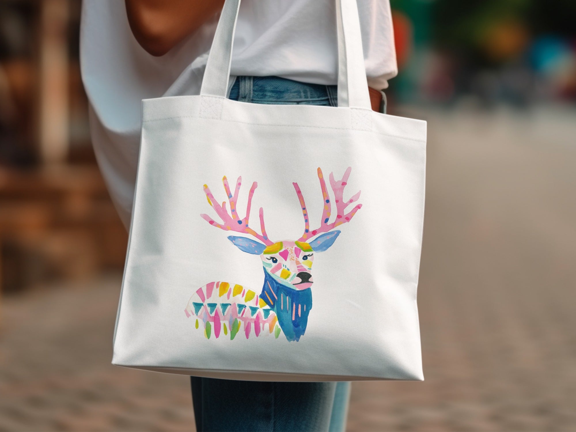 White tote bag with colorful, abstract geometric deer design.