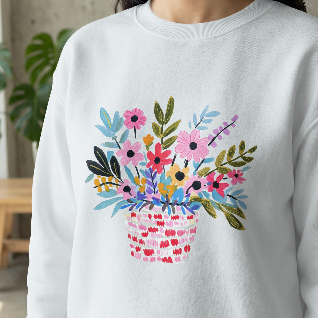 White sweatshirt with colorful floral basket design.