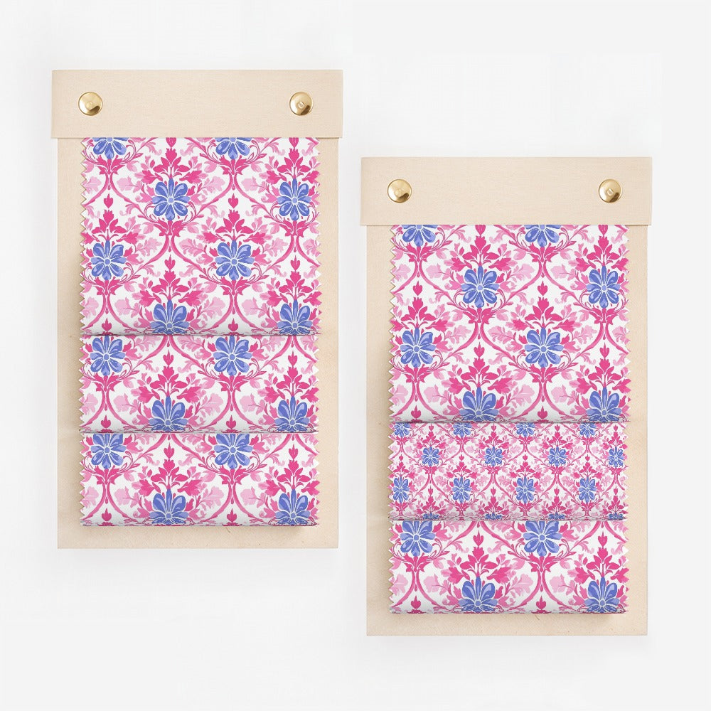 Two fabric swatches with a pink and blue floral pattern on a wooden board.