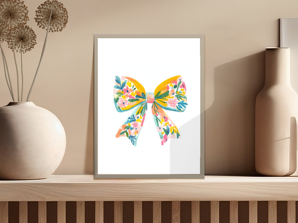 Watercolor floral bow art print in a white frame.