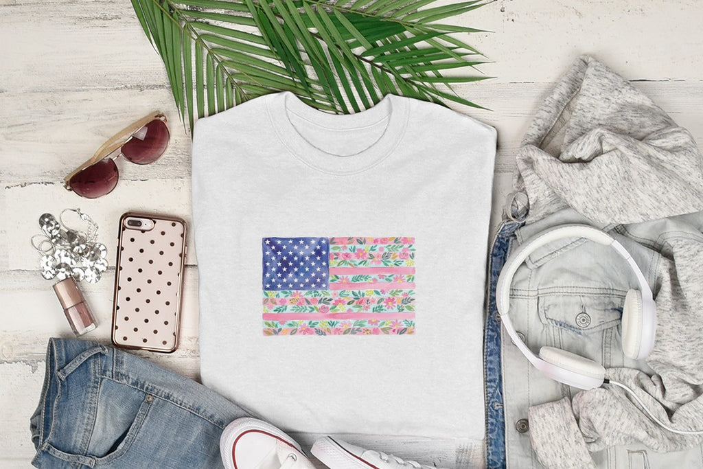 White t-shirt with American flag design made of pink flowers and green leaves.