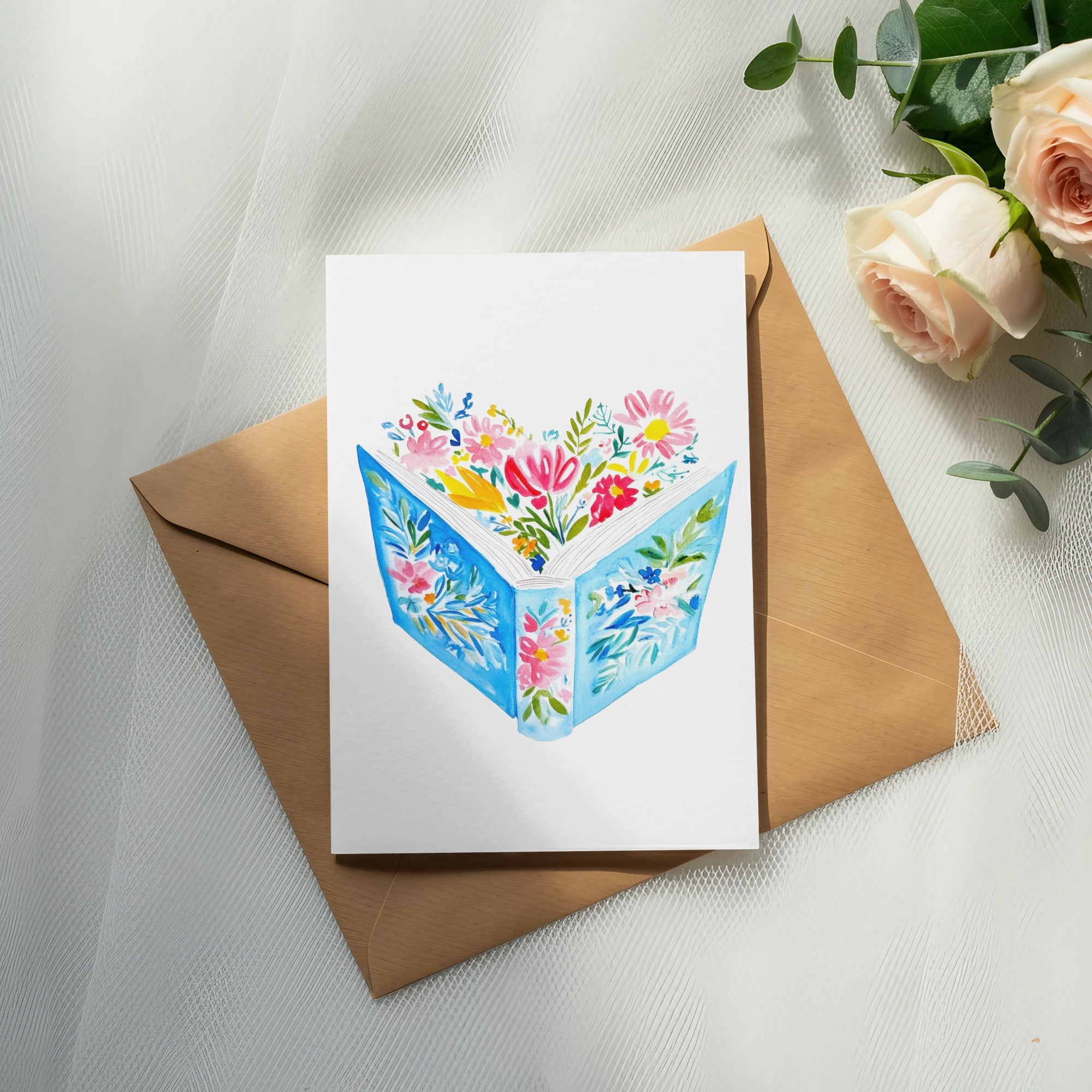 Watercolor illustration of an open book with flowers spilling out, on a brown envelope.