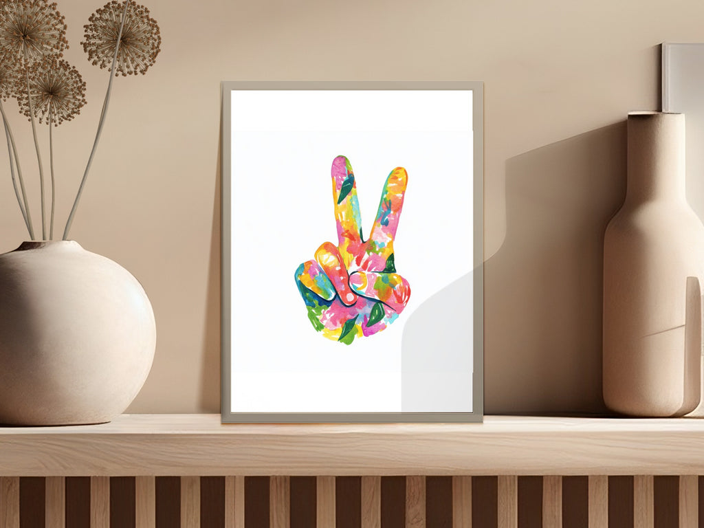 Colorful peace sign artwork in a white frame on a shelf.
