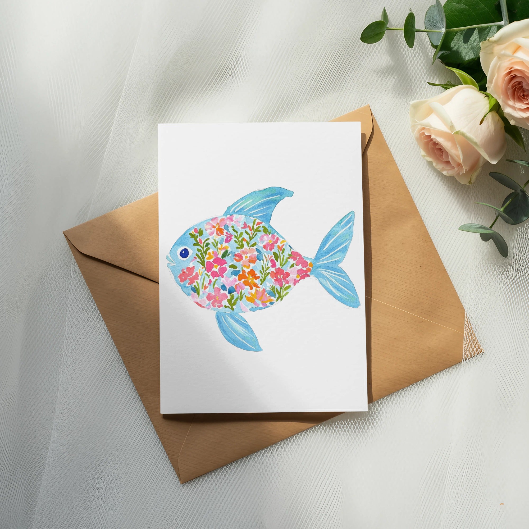 Card with a blue fish design filled with colorful flowers, on a kraft envelope.