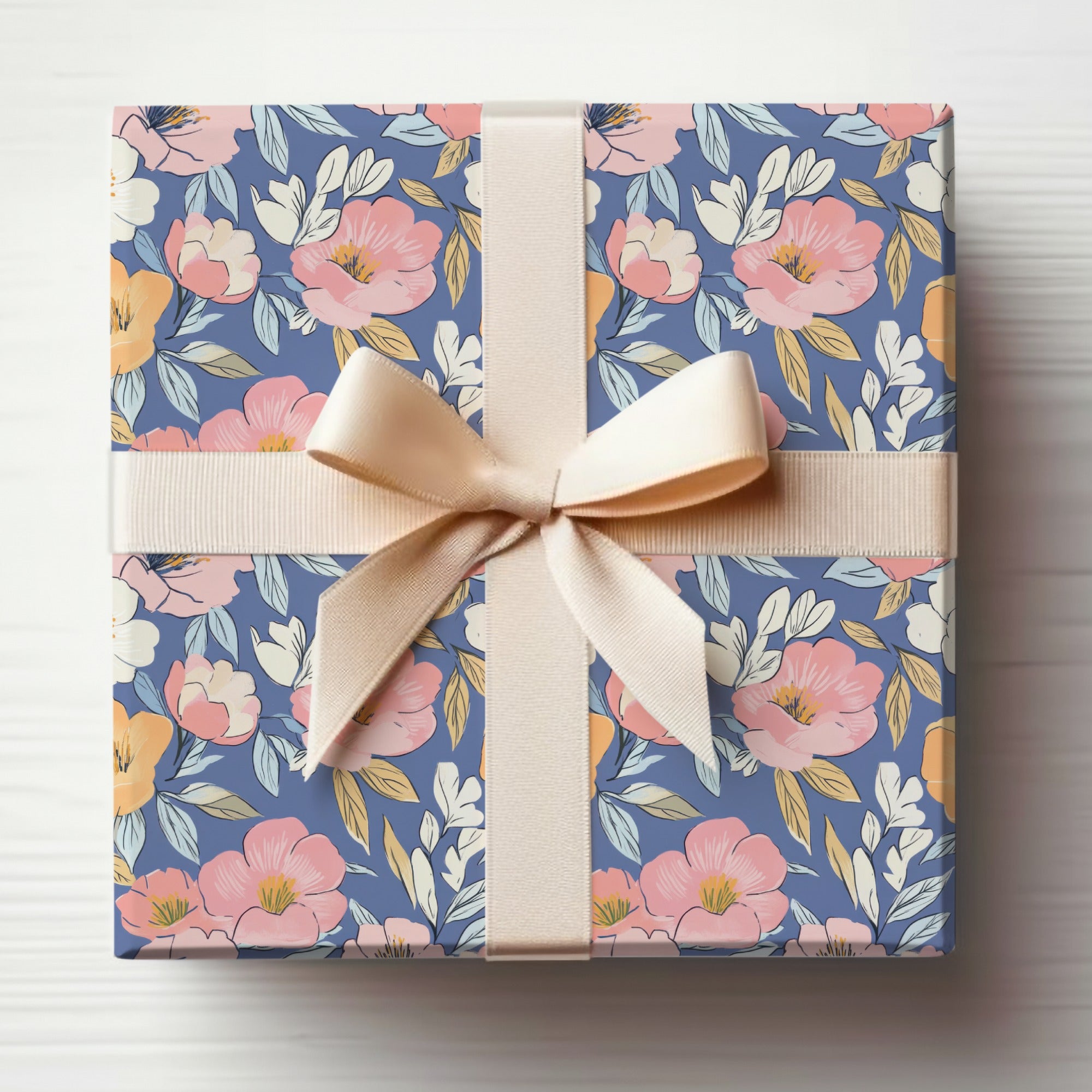 Gift box wrapped in floral paper with a light pink ribbon bow.