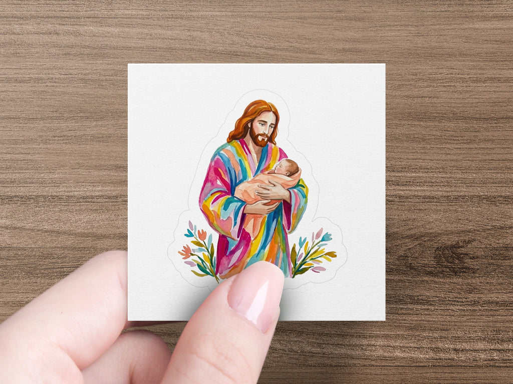 Jesus holding a baby, wearing a colorful robe, with floral accents.