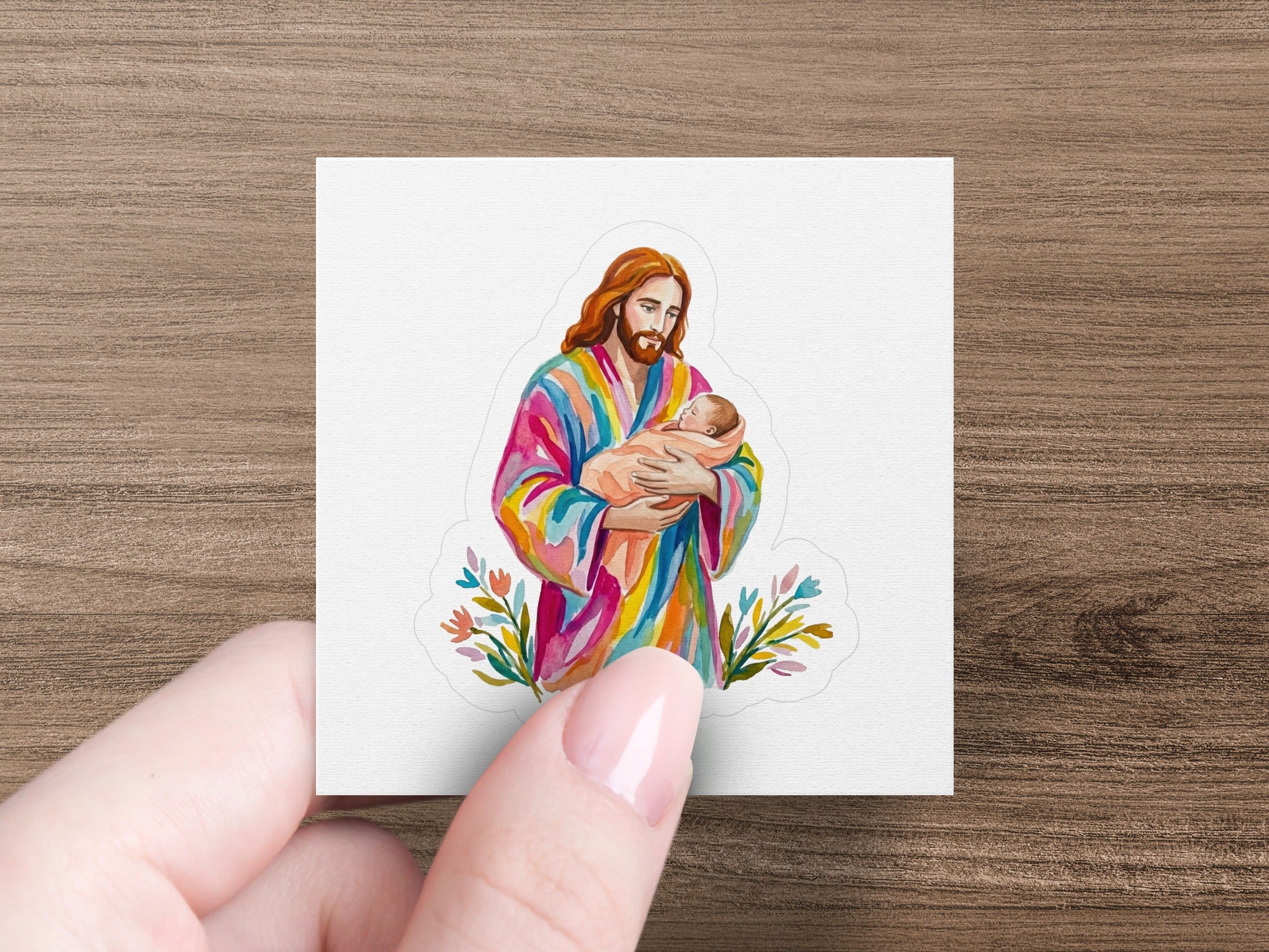 Jesus holding a baby, wearing a colorful robe, with floral accents.