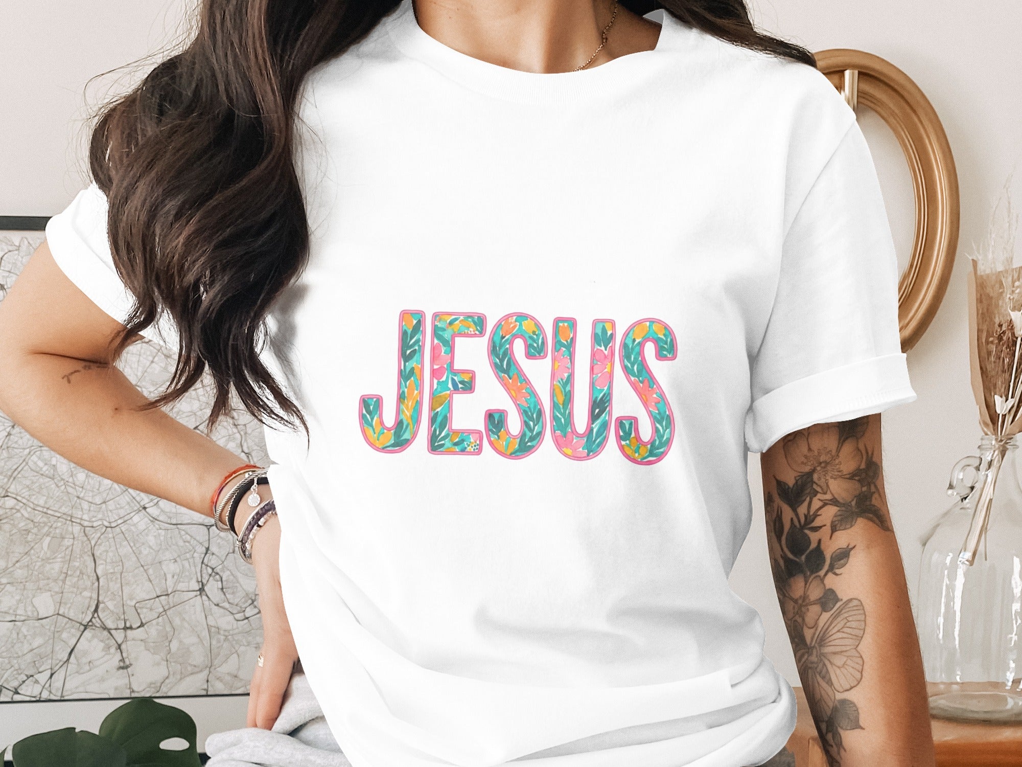 White t-shirt with "JESUS" in colorful floral lettering.