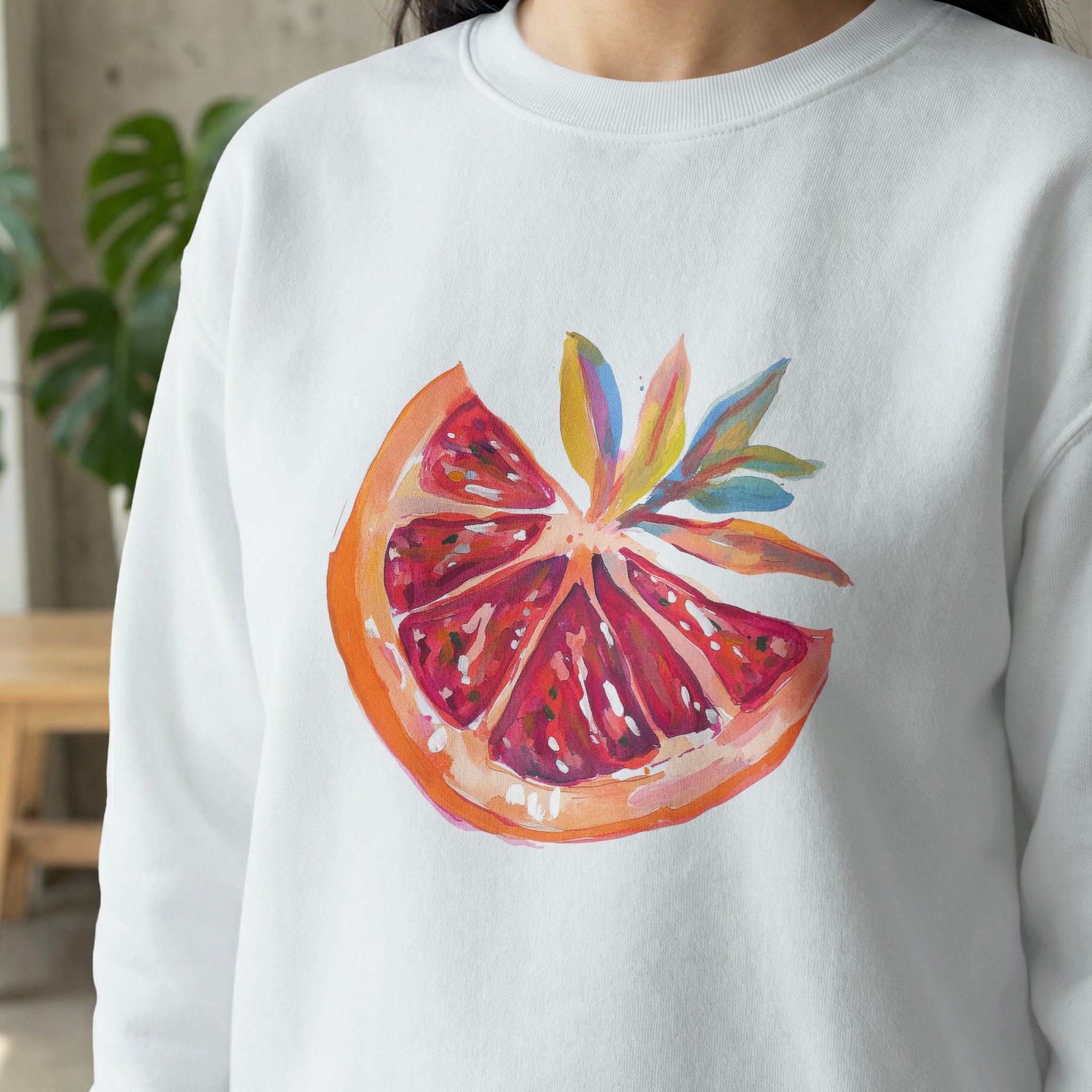 White sweatshirt with a painted grapefruit slice design.