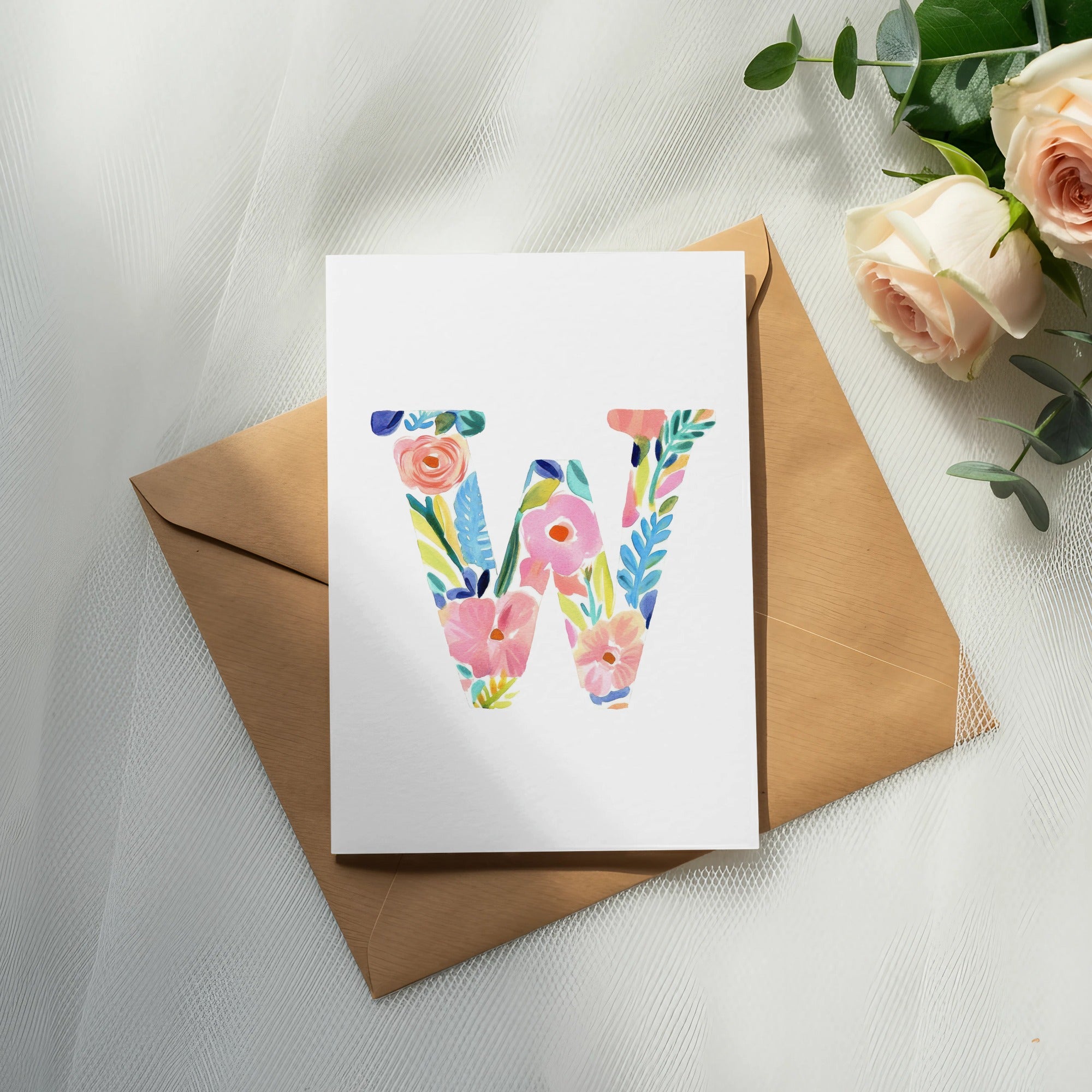 Watercolor letter W with flowers on an envelope with roses.