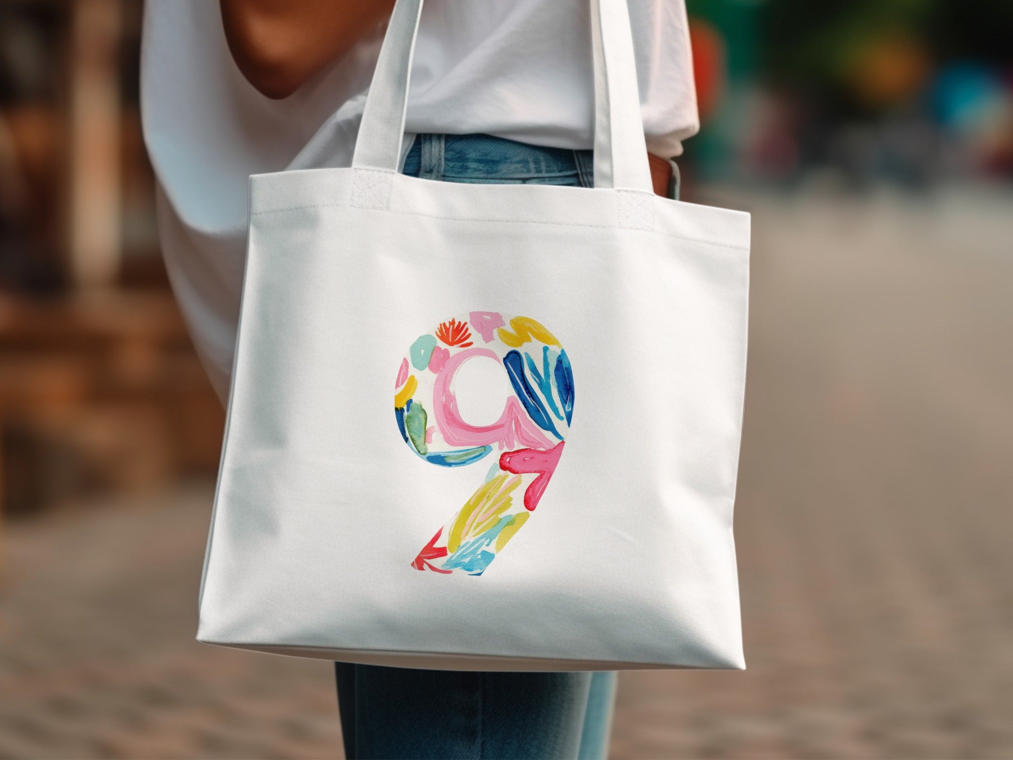 White tote bag with colorful floral number 9 design.