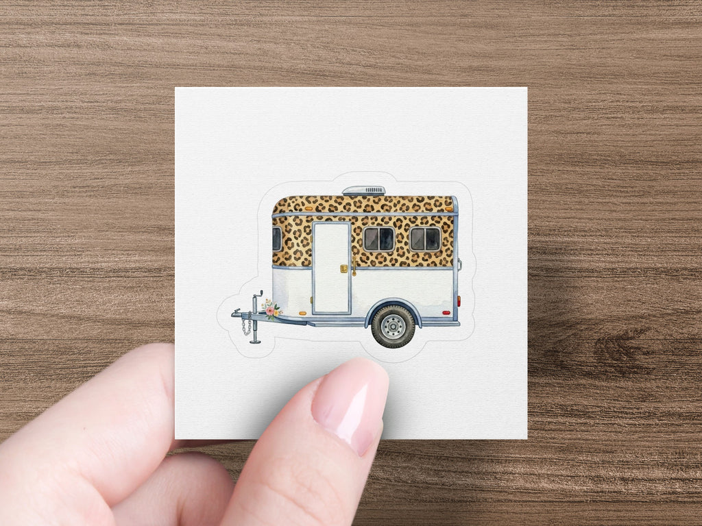 Camper trailer with leopard print pattern on roof and sides.