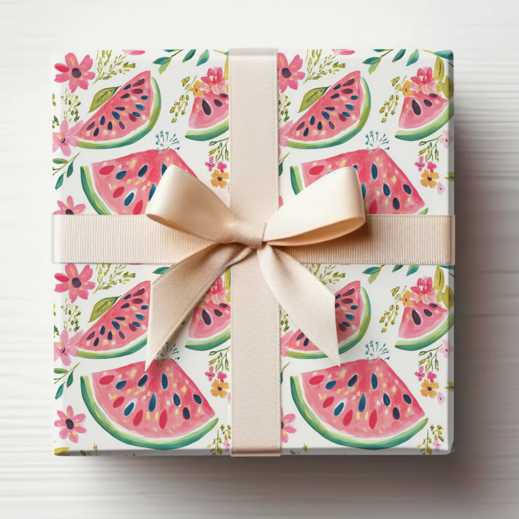 Gift-wrapped box with watermelon slices and floral pattern, tied with a light pink ribbon.