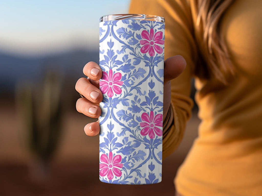 Person holding a blue and white floral patterned tumbler with pink flowers.