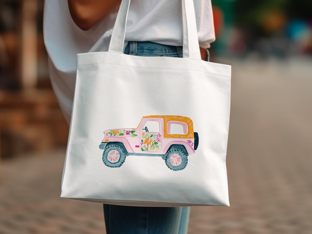 White tote bag with a watercolor illustration of a pink and orange jeep with flowers.