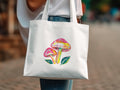 White tote bag with colorful mushroom and leaf watercolor illustration.