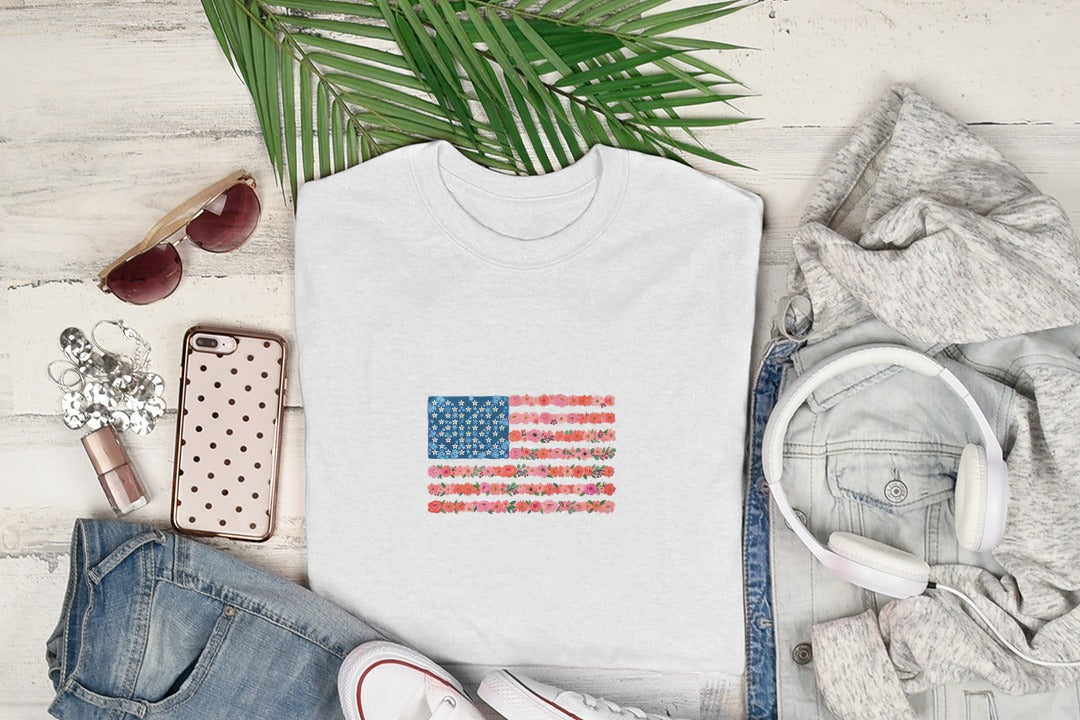 White t-shirt with American flag design made of colorful flowers.