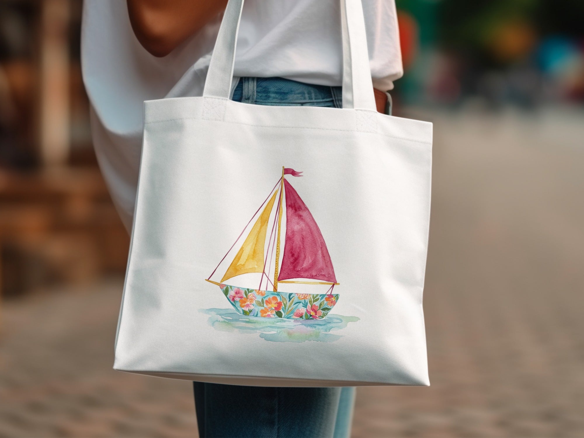 White canvas tote bag with a watercolor sailboat illustration.