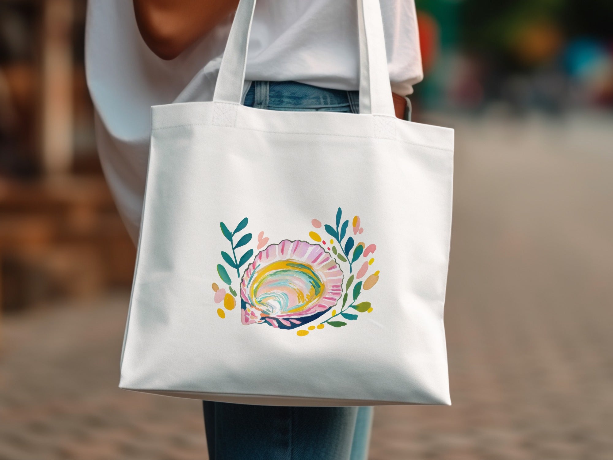 White tote bag with colorful shell and leaf graphic.