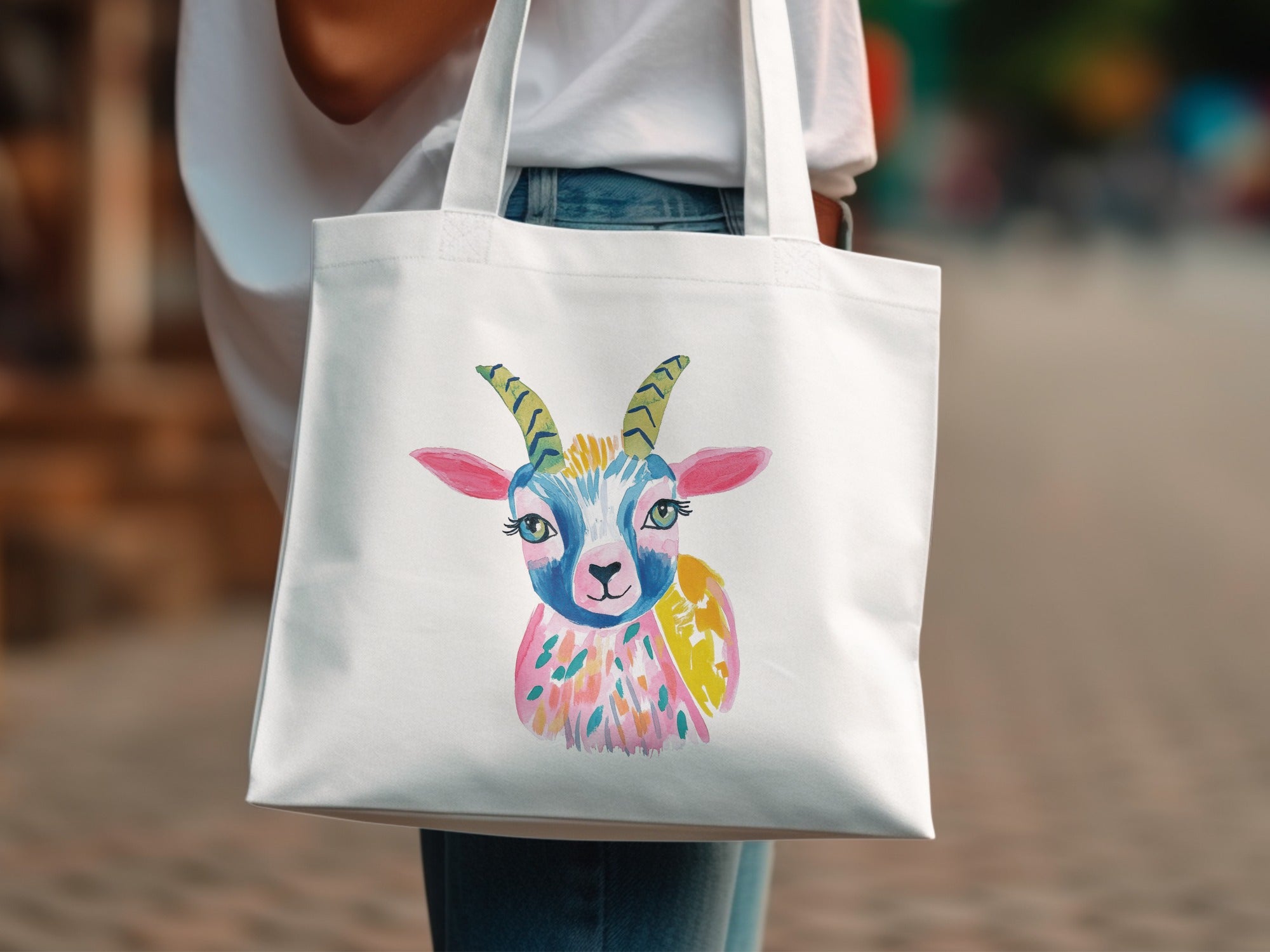 White tote bag with a colorful watercolor illustration of a goat's head.