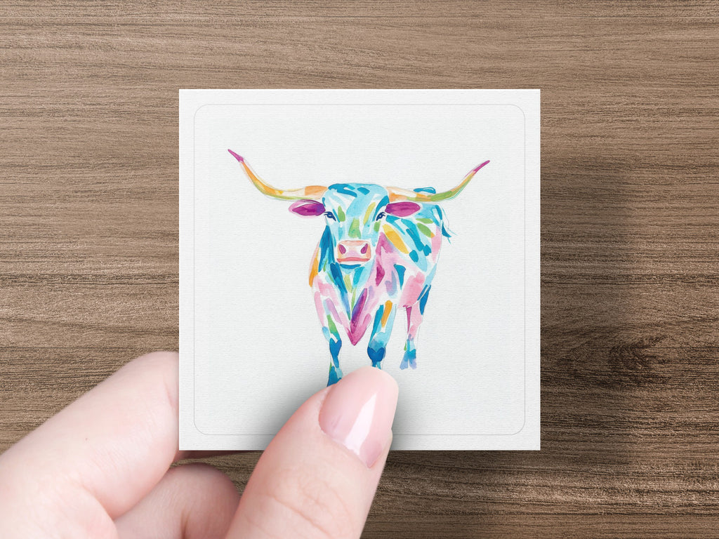 Colorful abstract Texas Longhorn illustration on a white card held by a hand.