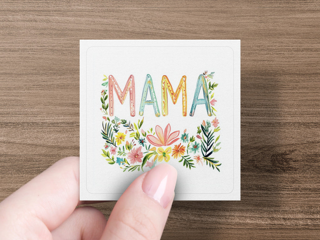 Card with colorful floral "MAMA" lettering held by fingers.