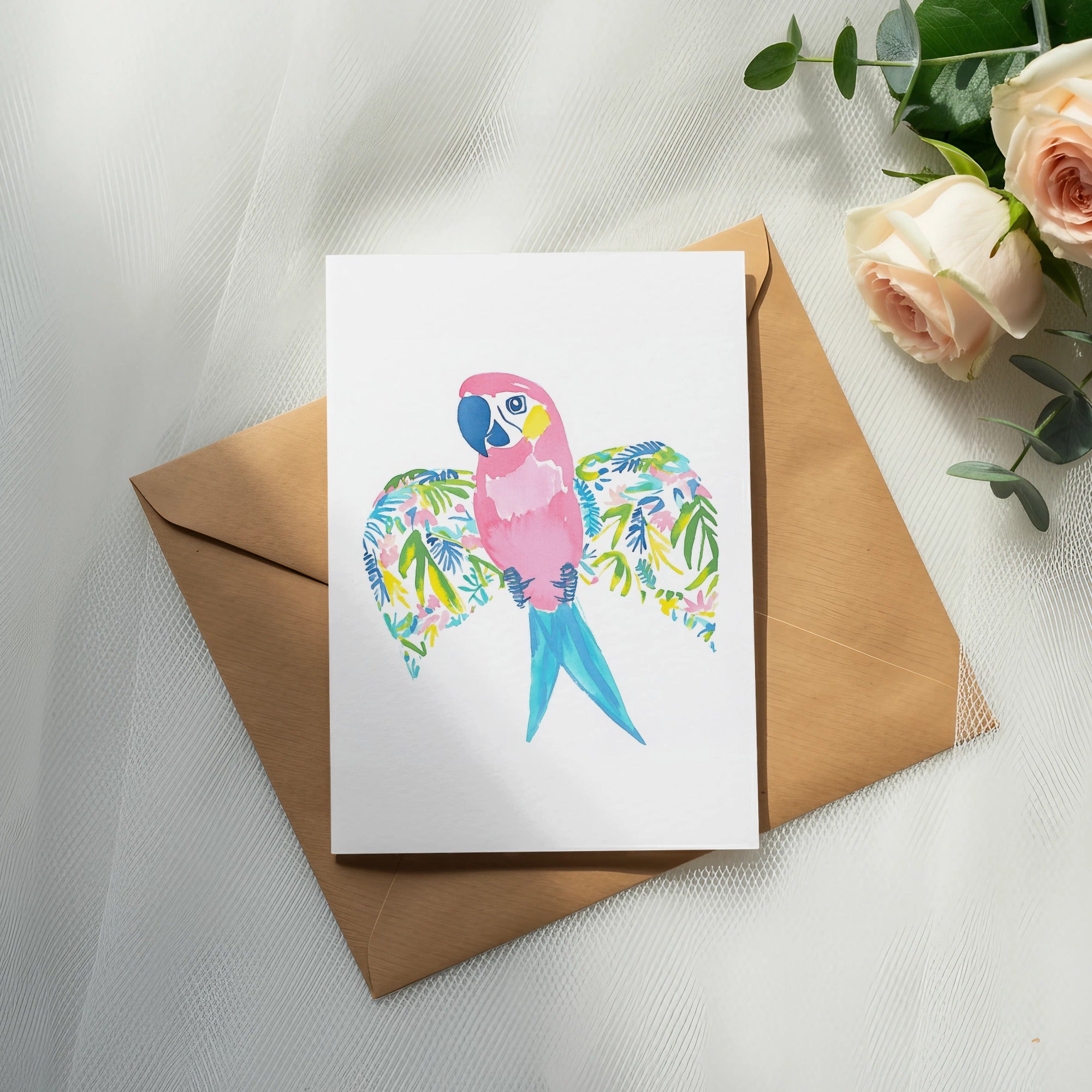Watercolor parrot card with floral wings on a brown envelope.