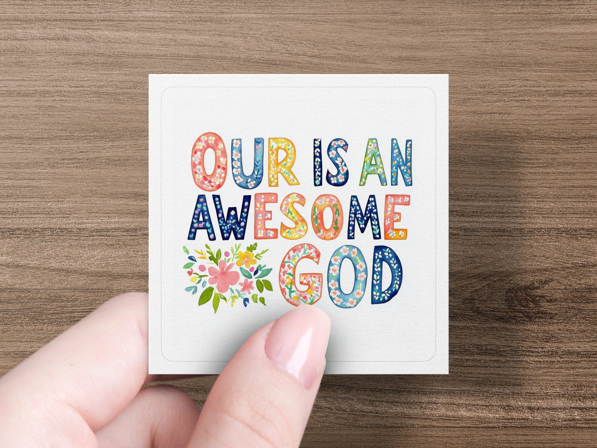Square sticker with colorful text "OUR IS AN AWESOME GOD" and floral accents.