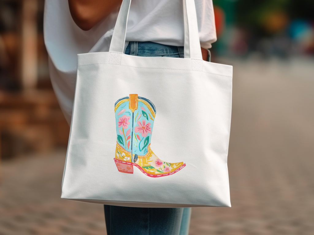 White tote bag with a colorful embroidered cowboy boot illustration.