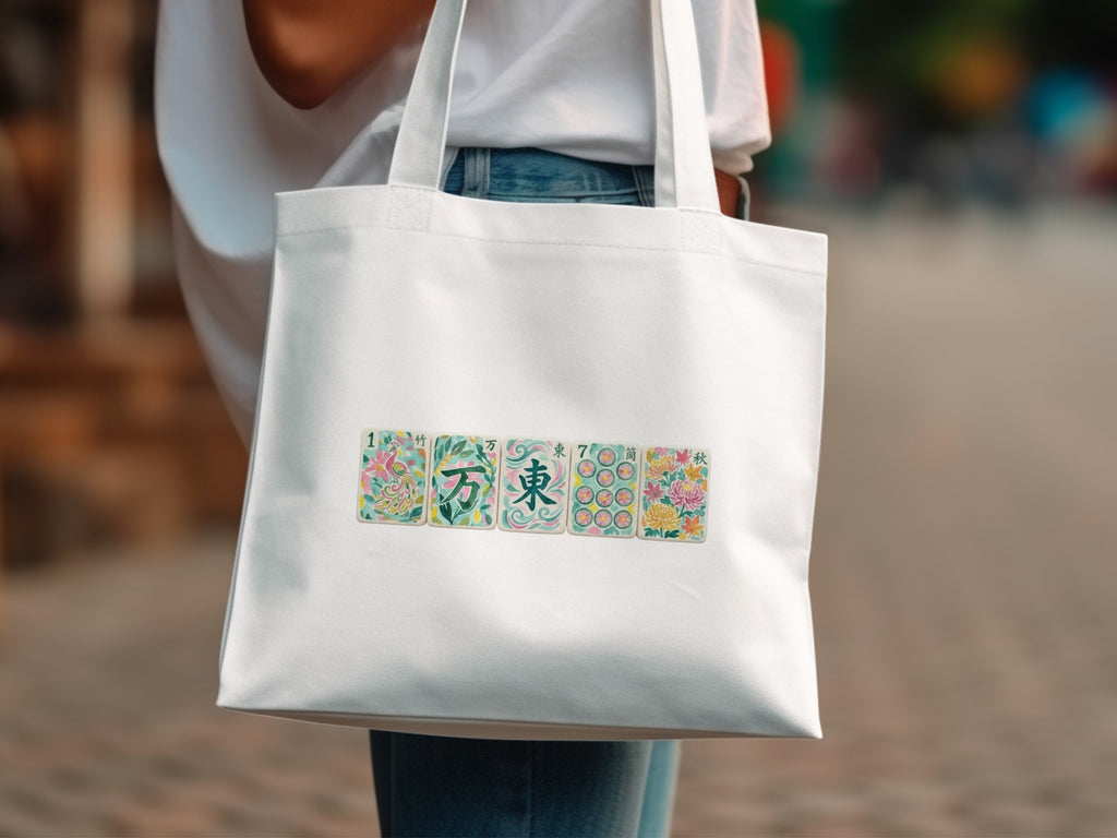 White tote bag with colorful floral and character card designs.