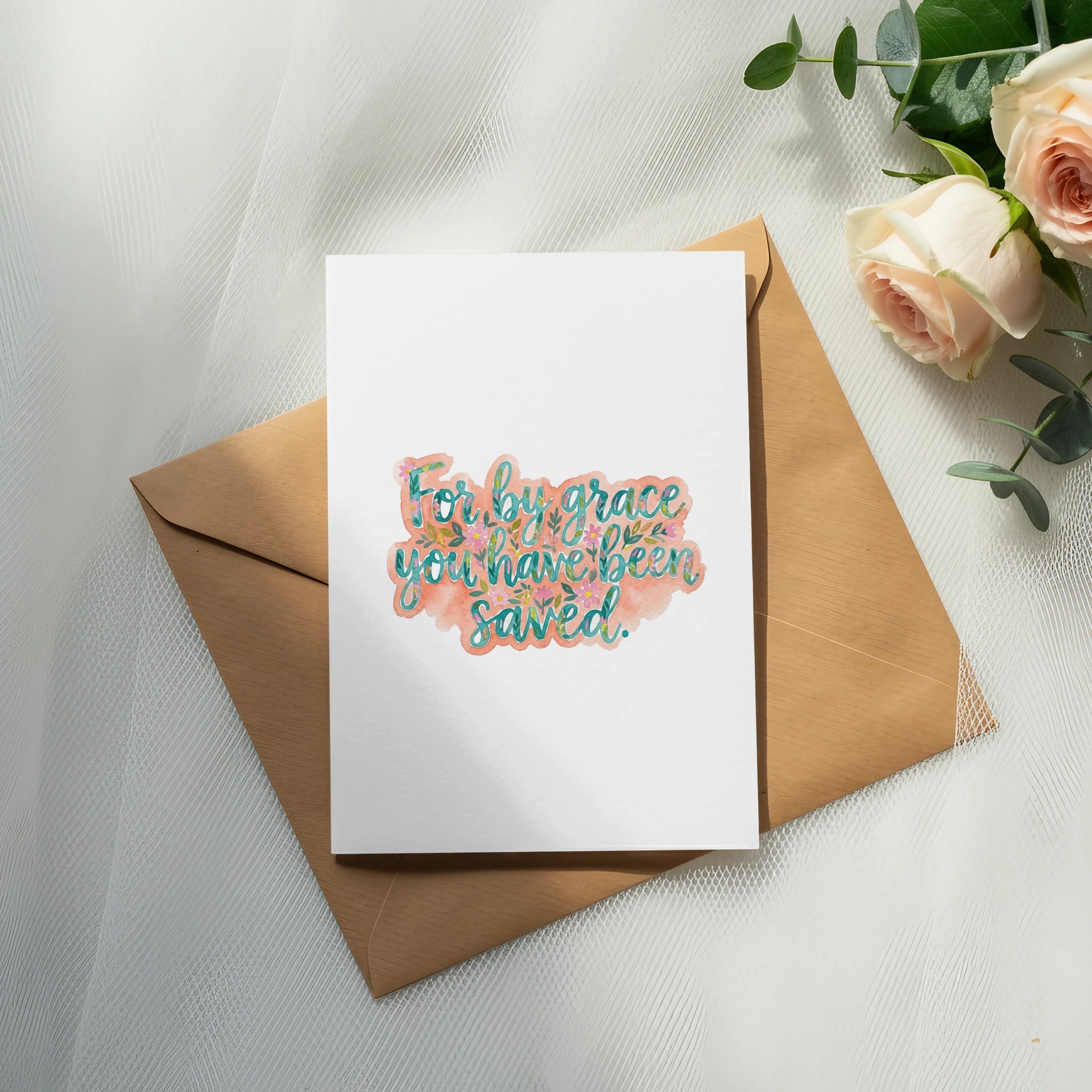 Card with "For by grace you have been saved" text, next to envelope and roses.