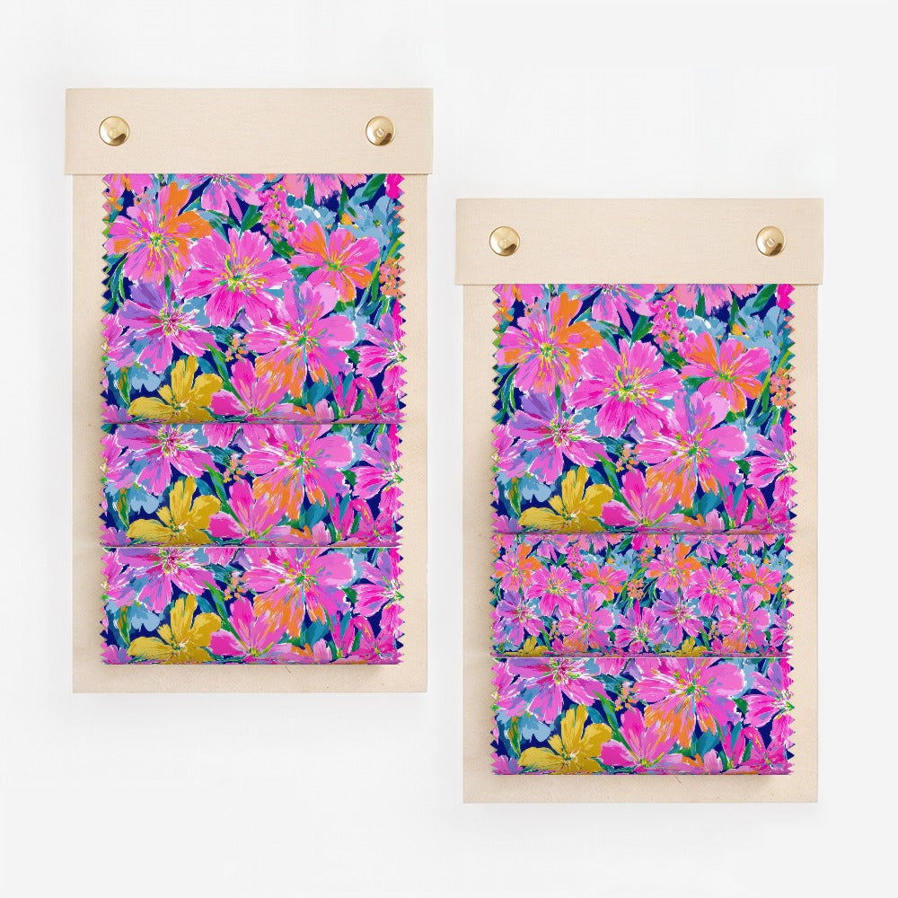 Two swatches of fabric featuring vibrant pink, yellow, and blue floral patterns.
