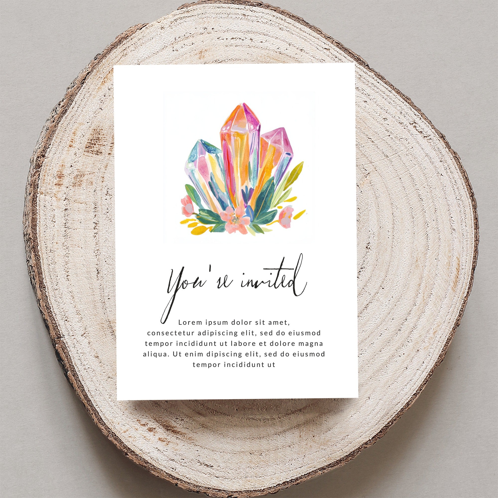 Invitation with watercolor crystals, flowers, and "You're invited" text.