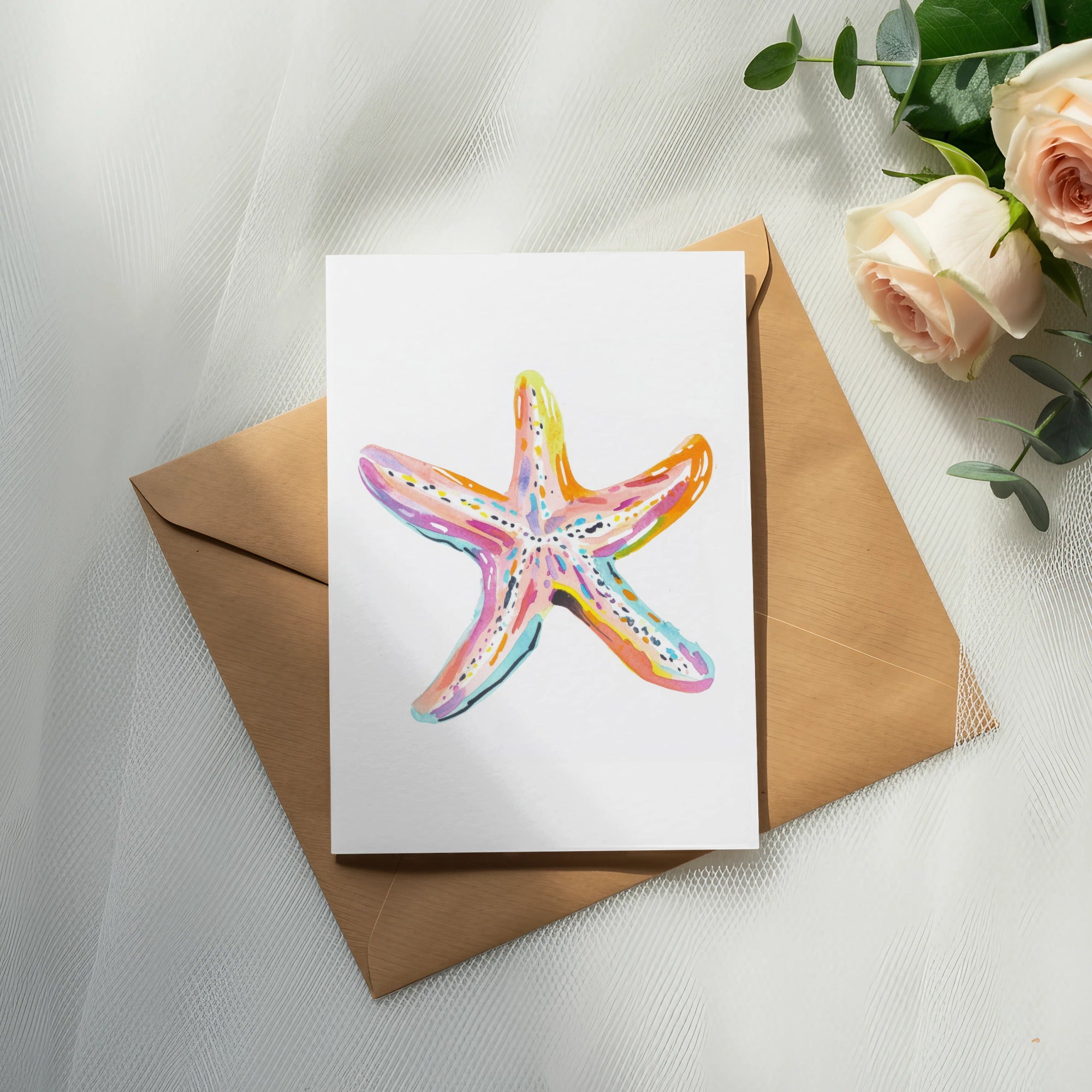 Watercolor starfish illustration on a card with roses and eucalyptus.