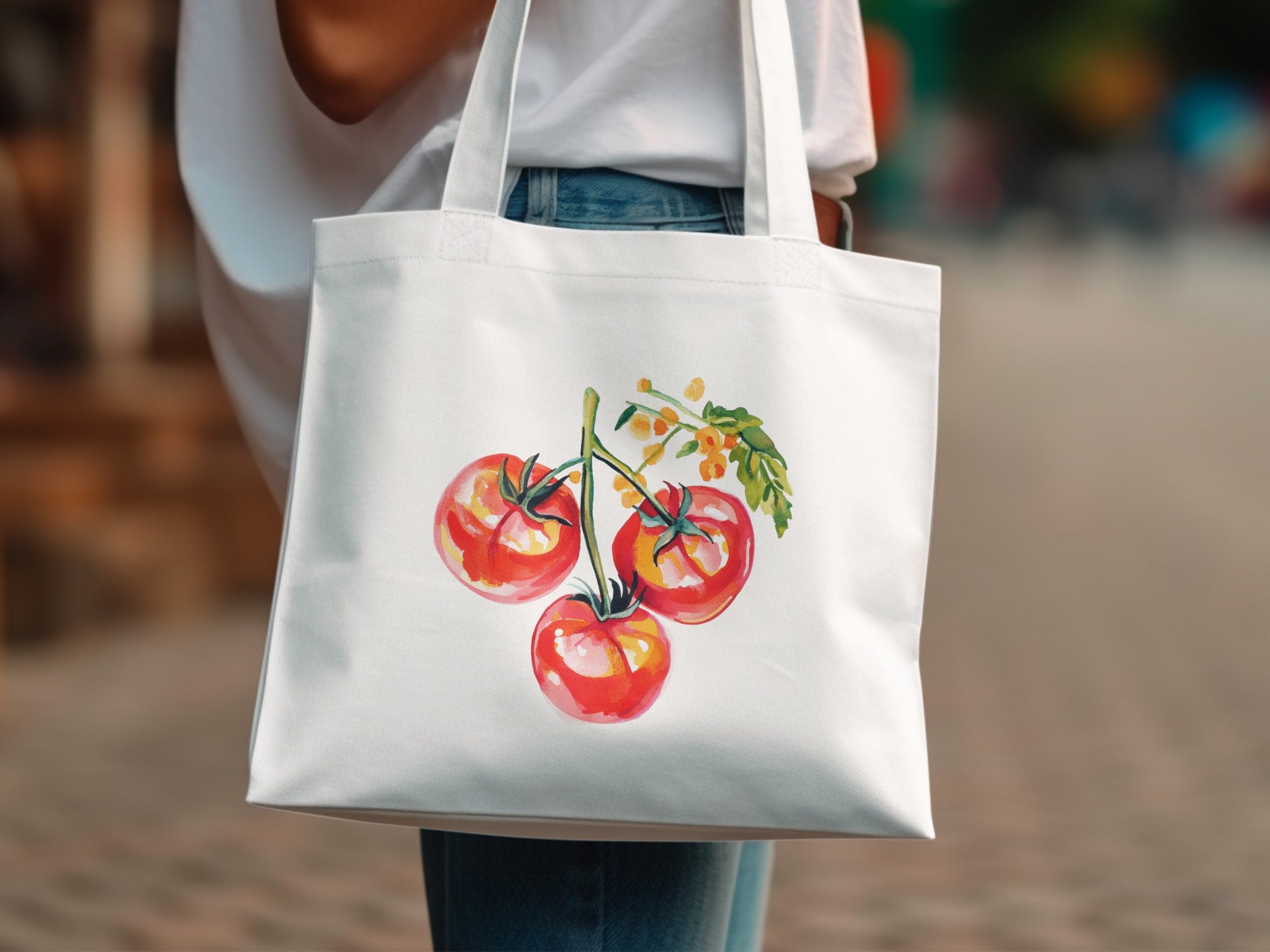 White tote bag with watercolor illustration of three red tomatoes on a vine.