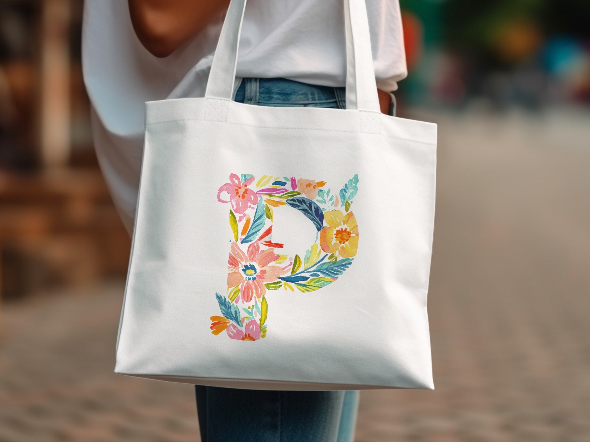White tote bag with colorful watercolor floral letter P design.