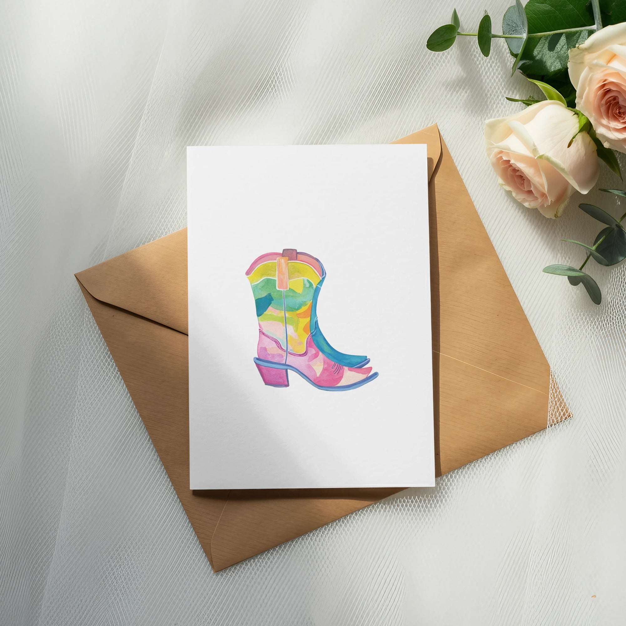 Watercolor cowboy boot illustration on a card, resting on a kraft envelope.