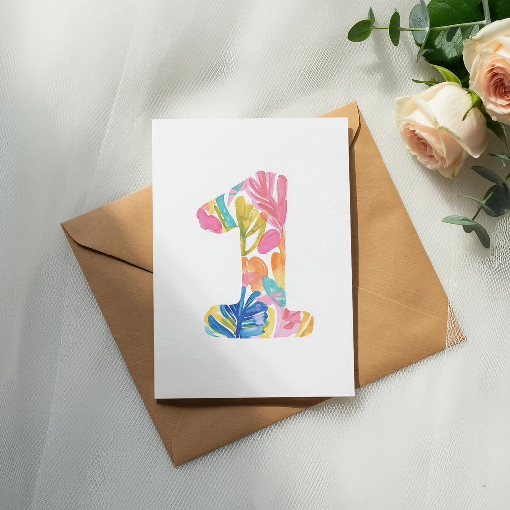Card with colorful "1" design on brown envelope with roses.