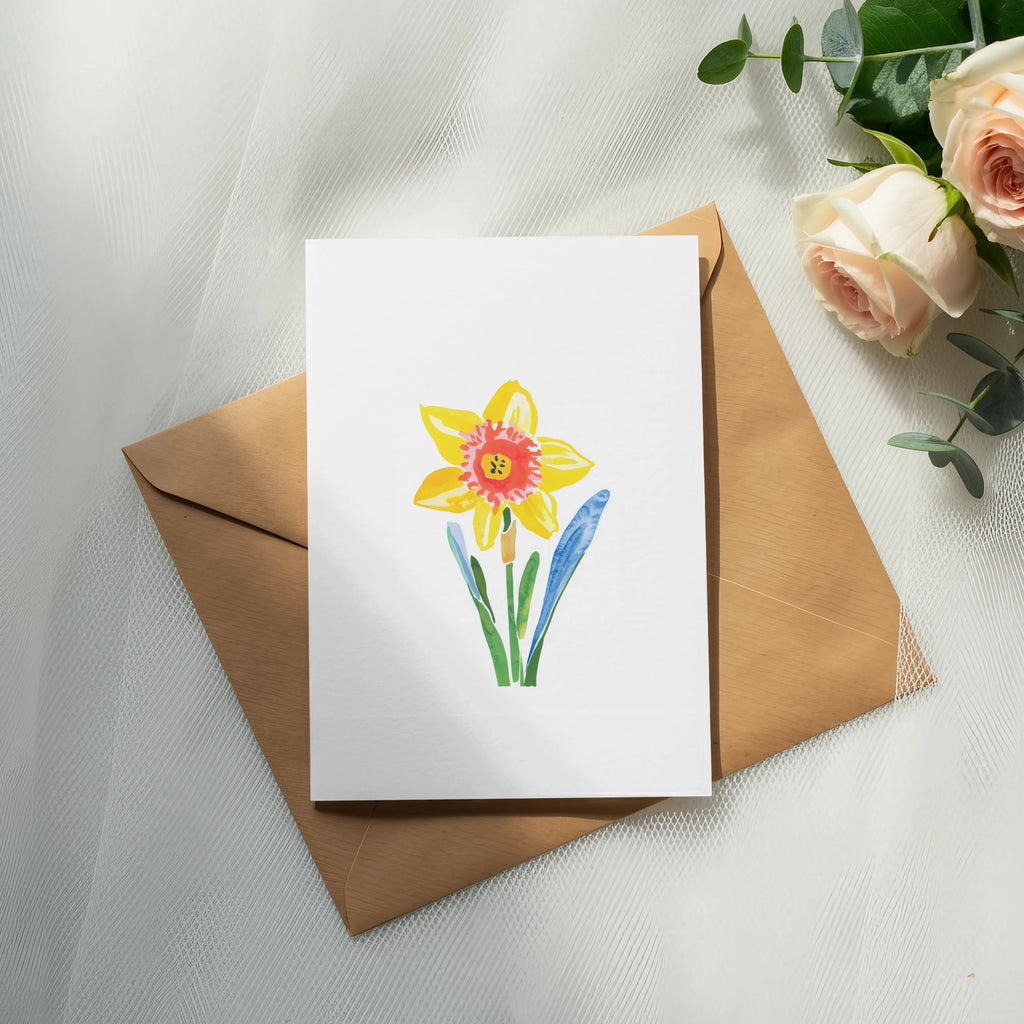 Watercolor daffodil illustration on a white card, atop a brown envelope.