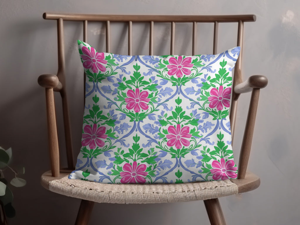 Throw pillow with pink floral and green leaf pattern on a wooden chair.