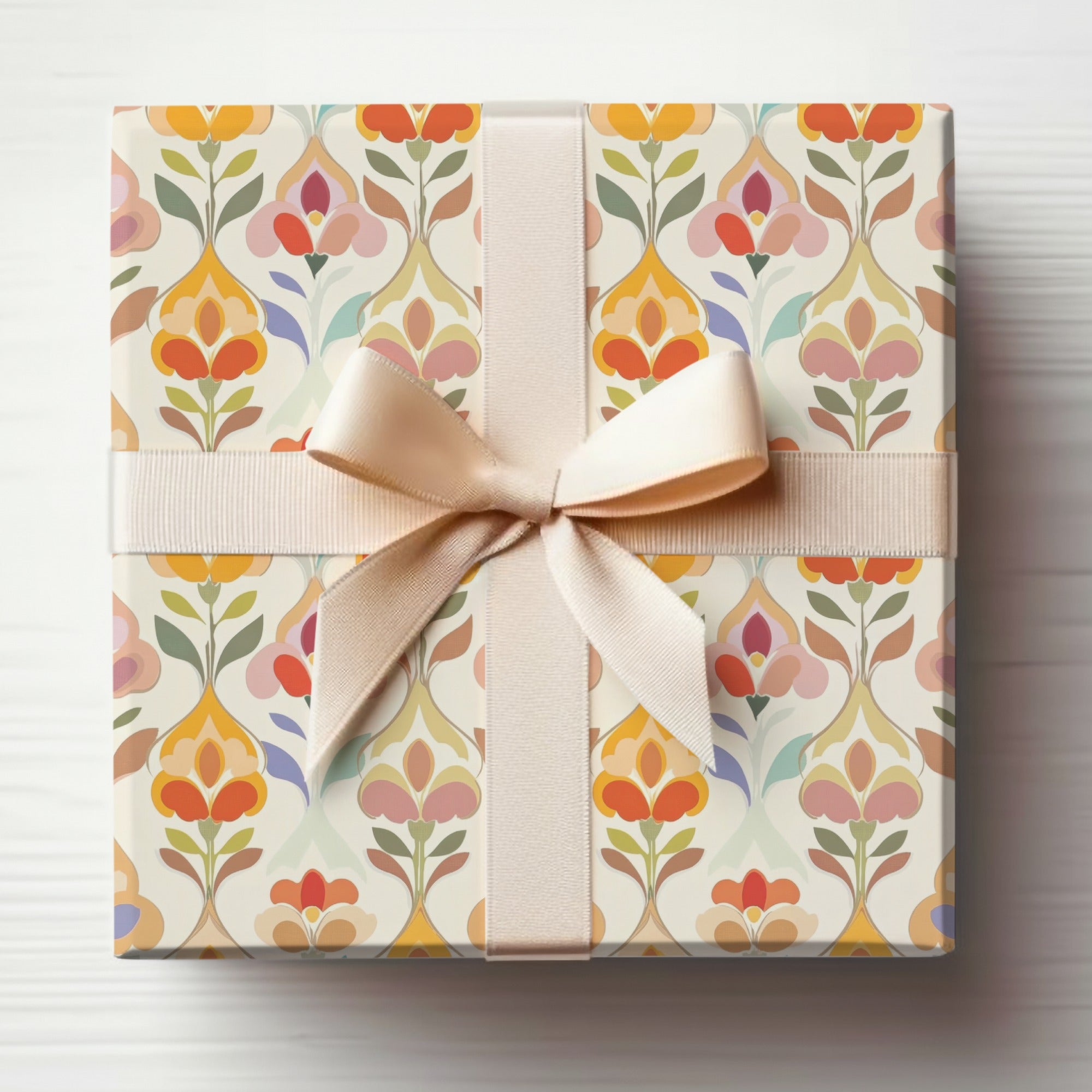 Gift-wrapped box with a beige ribbon and a floral pattern.