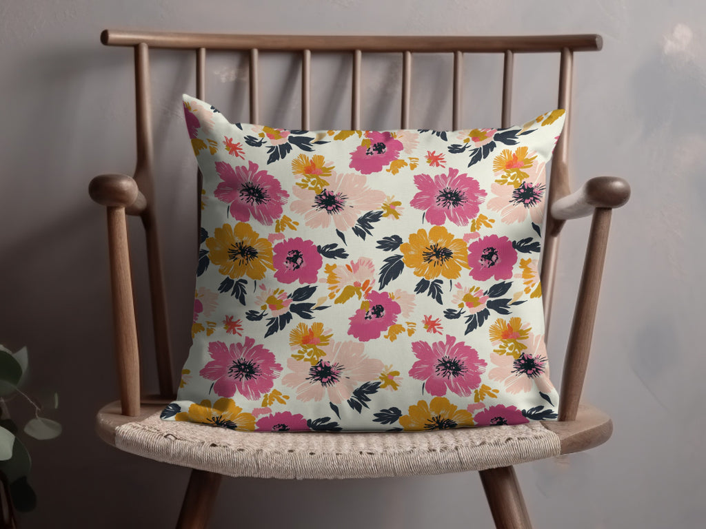 Decorative throw pillow with a pink, yellow, and coral floral pattern.