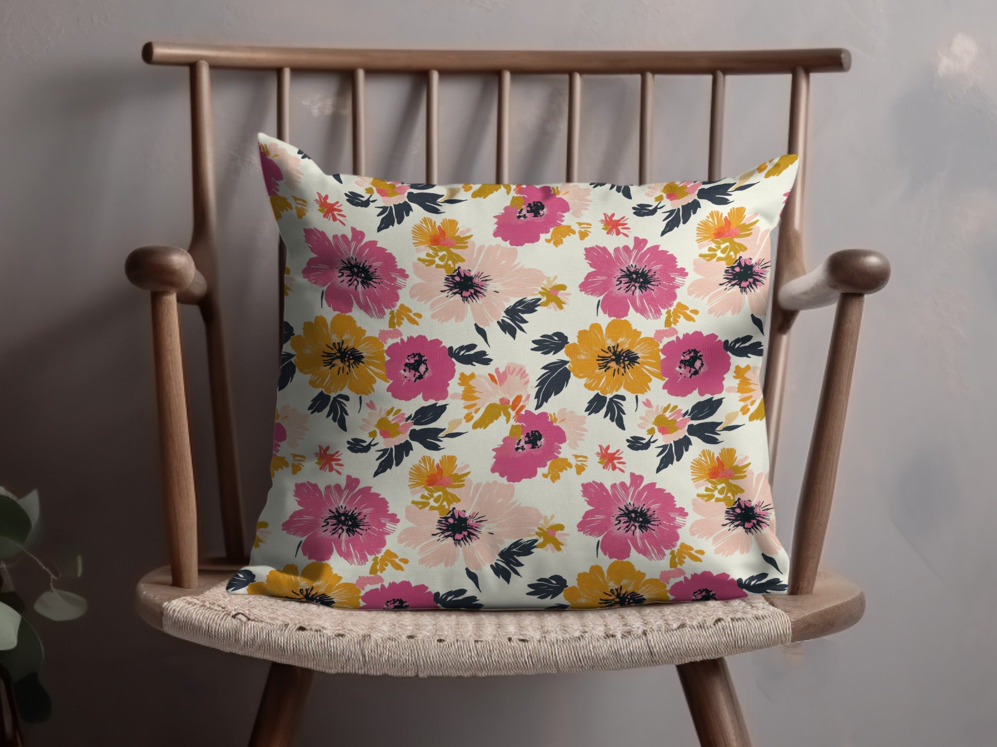 Decorative throw pillow with a pink, yellow, and coral floral pattern.