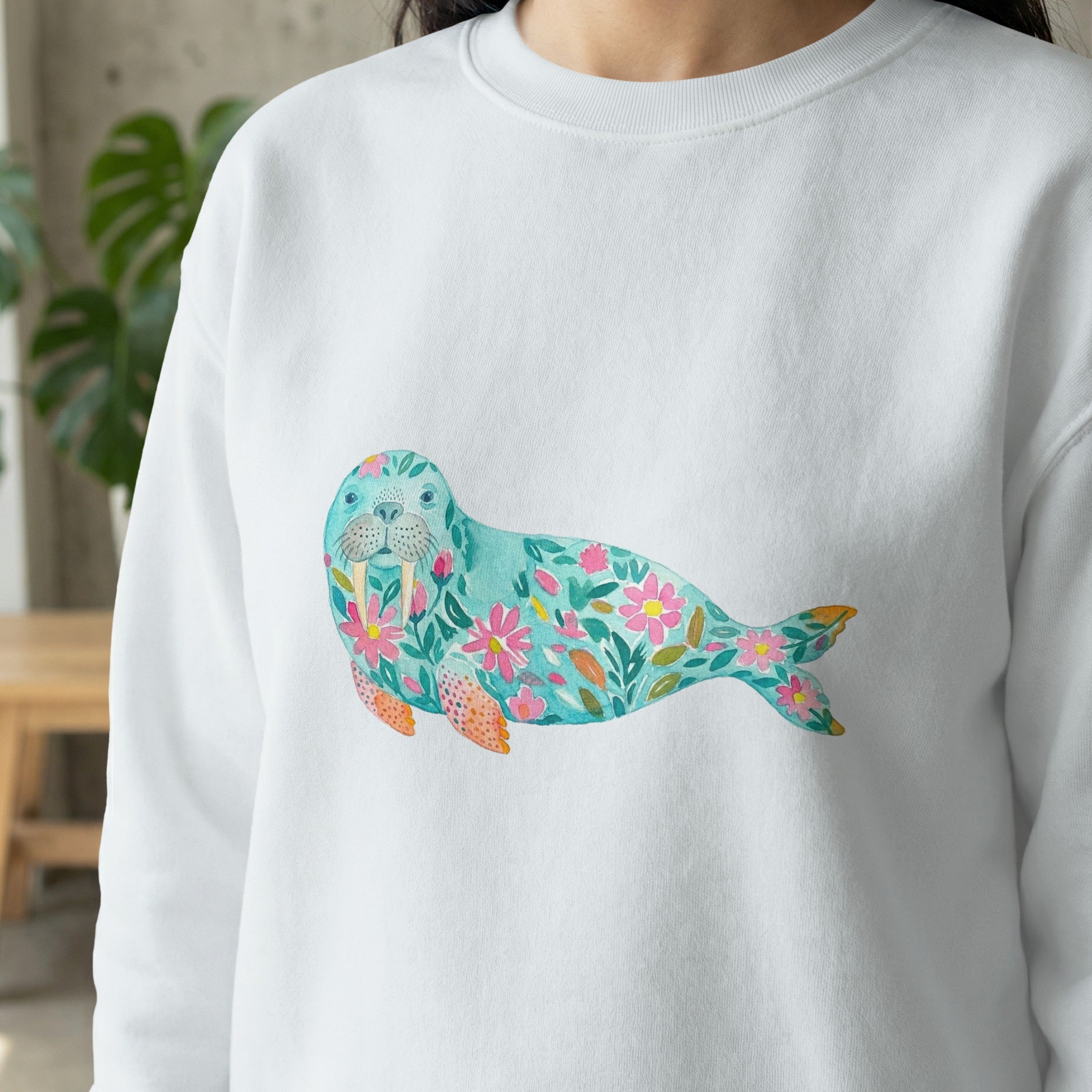 White sweatshirt with watercolor seal and floral design.