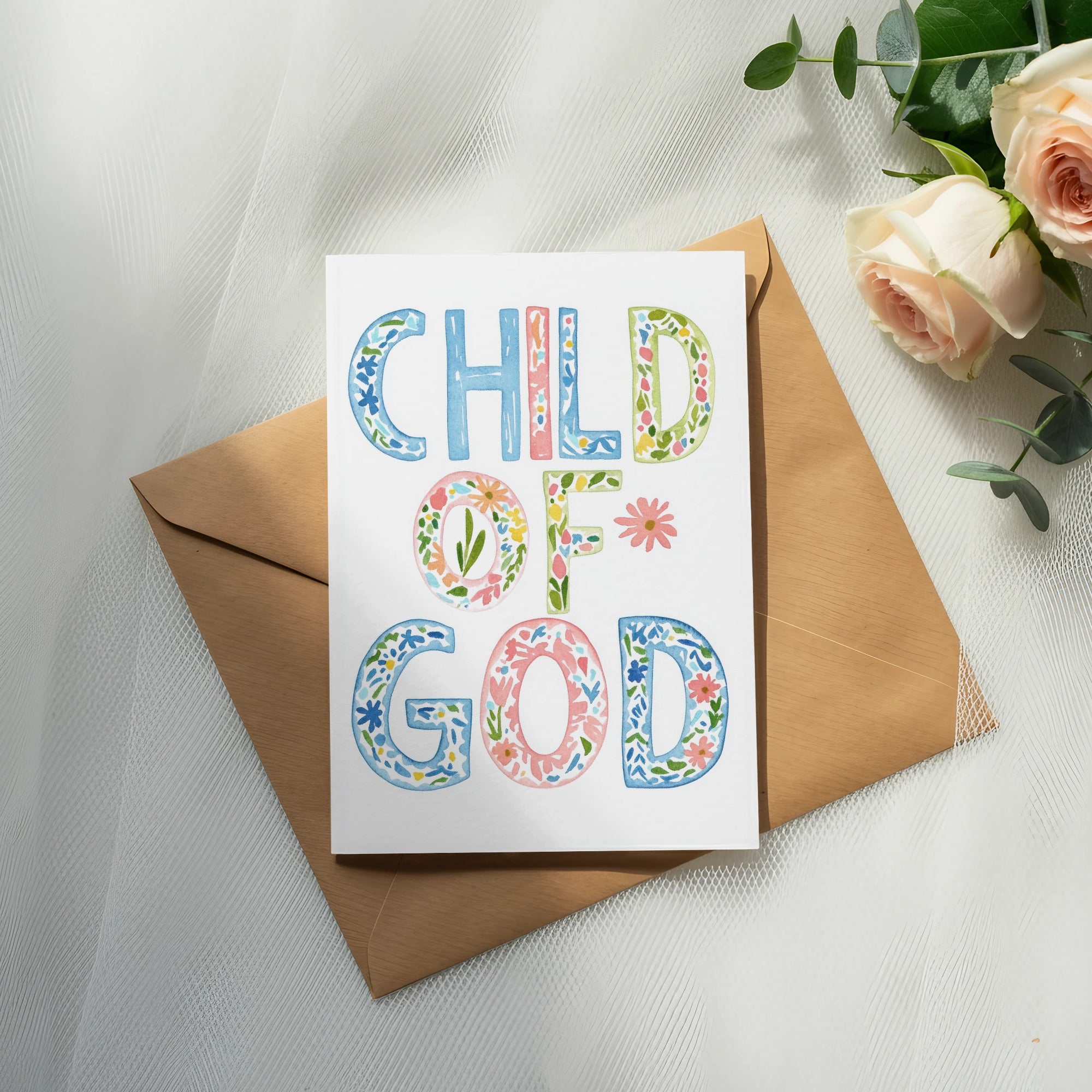 Card with watercolor lettering reading "Child of God" on an envelope with roses.